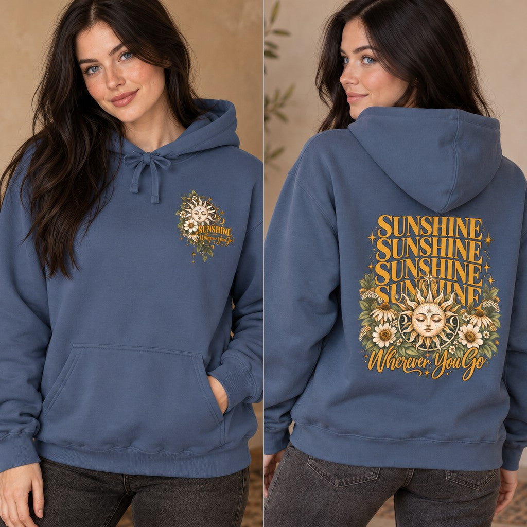Woman wearing a denim blue hoodie with a retro boho sun and floral face design, featuring repeated 'sunshine' text and positive message, lifestyle indoor setting, apparel for women who love uplifting and artistic designs, by Crossroads Dandelion