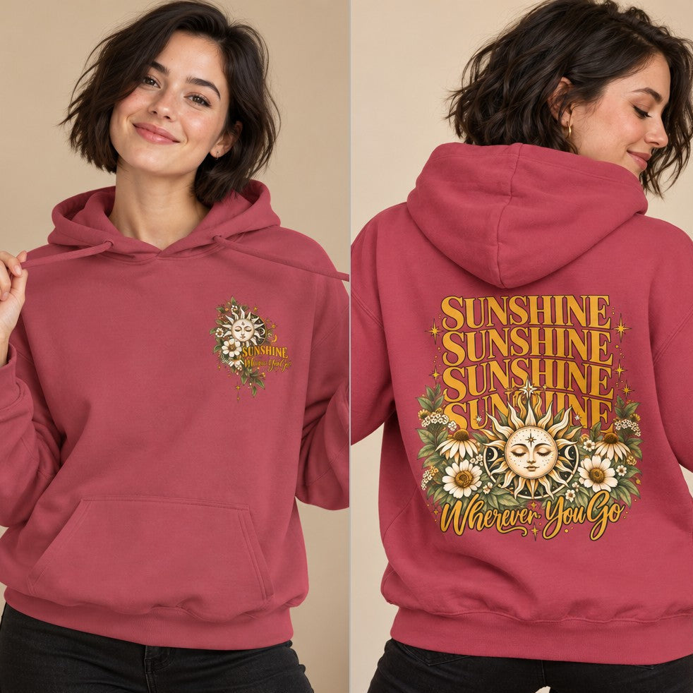 Woman wearing a crimson hoodie with retro-inspired sun and moon face design surrounded by daisies and foliage, large 'Sunshine Wherever You Go' text on back, cozy casual style, ideal for women who love vintage and boho looks, by Crossroads Dandelion