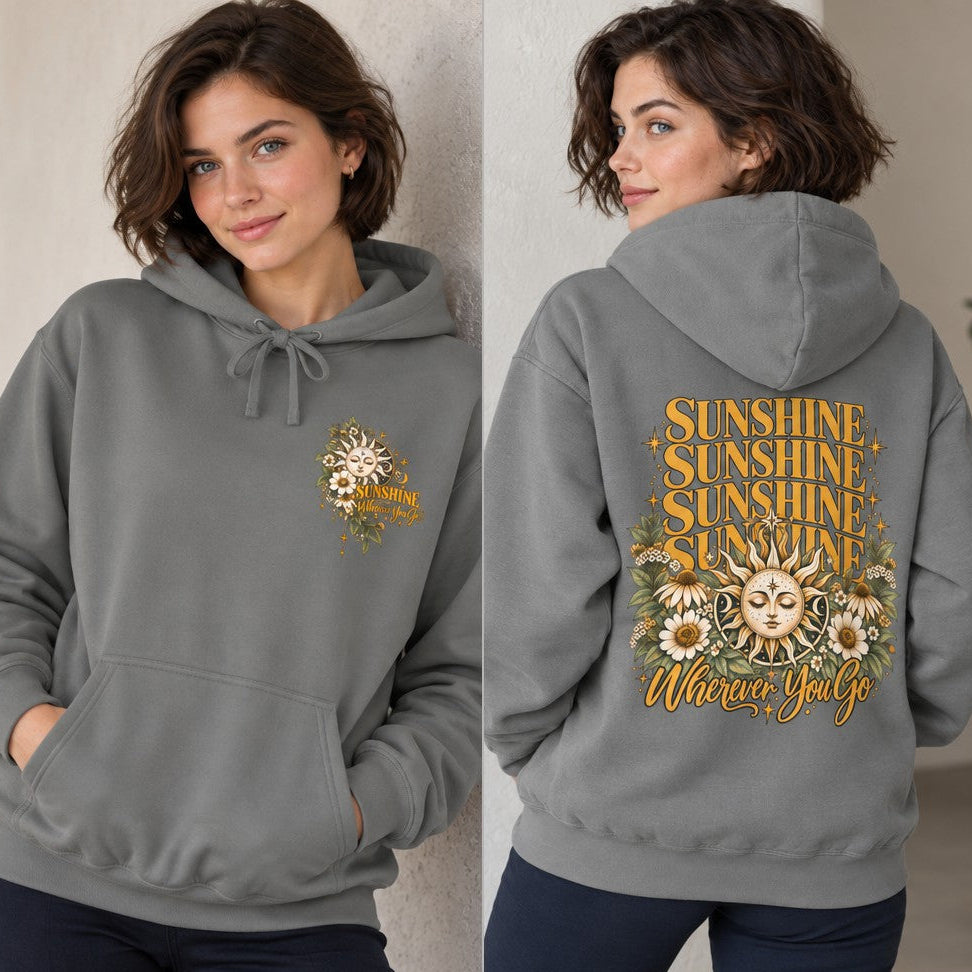 Woman wearing a grey hoodie featuring a vintage-inspired sun and daisy floral design with 'Sunshine Wherever You Go' text on the back, retro and boho style, casual indoor setting, women's cozy apparel for positive vibes, by Crossroads Dandelion