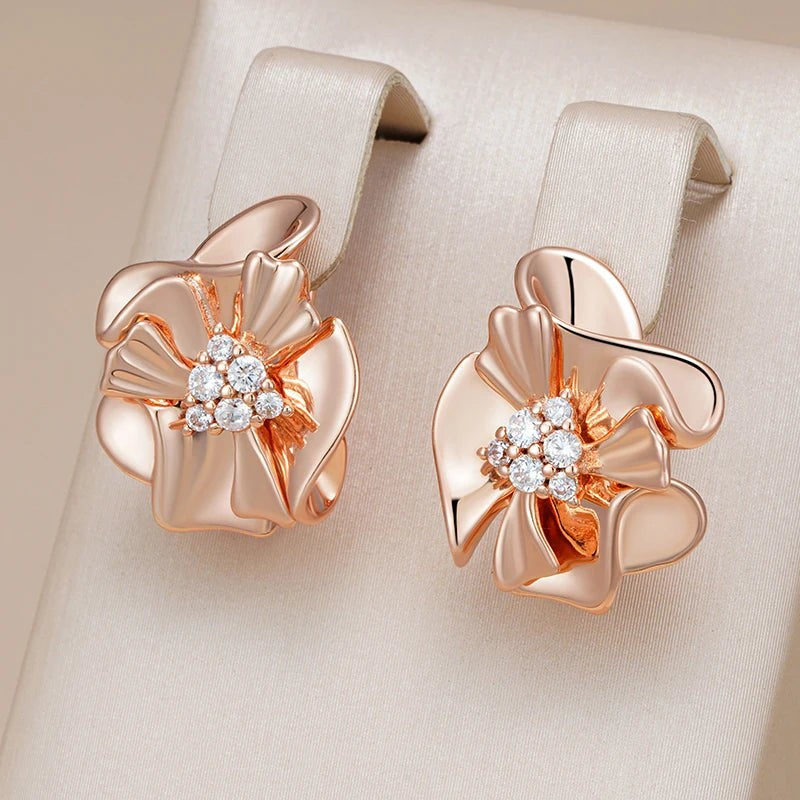 Ruffled flower earrings hanging from a cream satin jewelry display