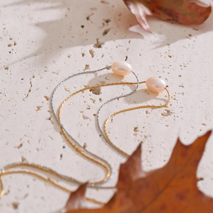 Two single freshwater pearl necklaces in gold and silver with a red autumn leaf