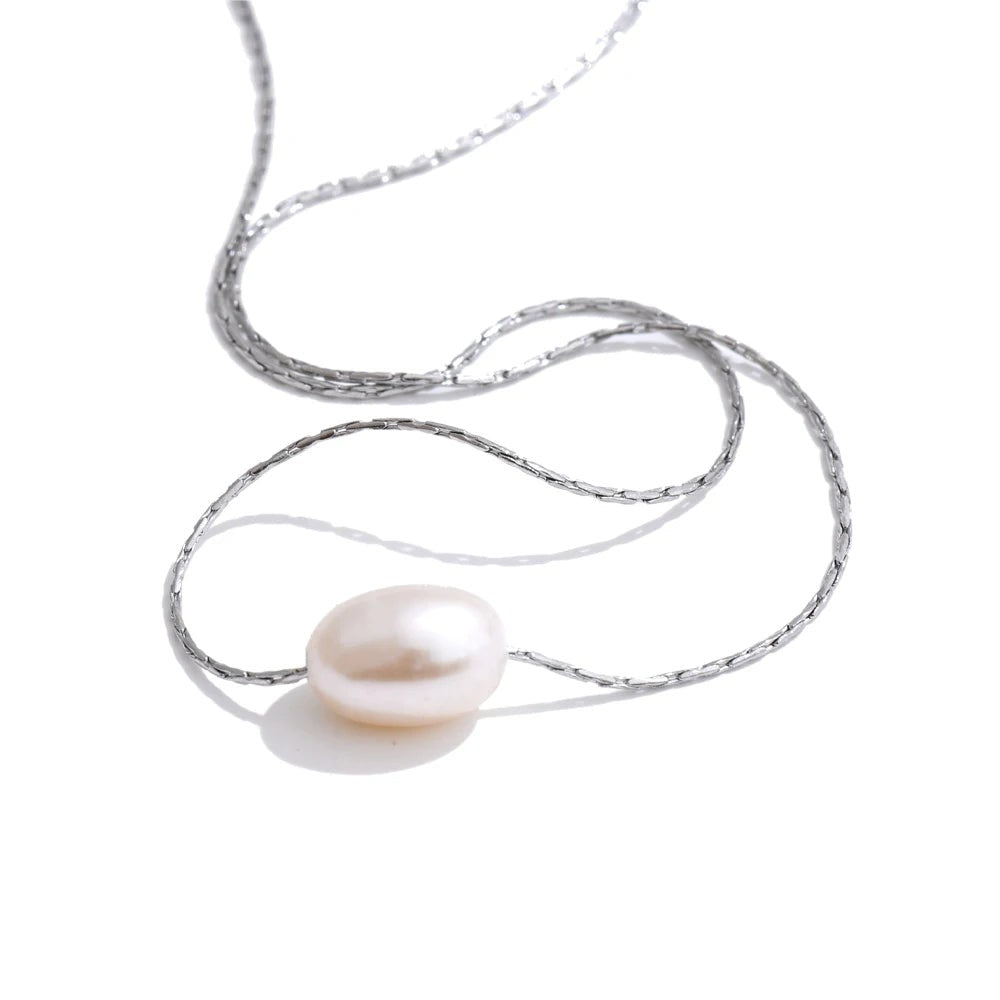 Single oval freshwater pearl on a fine silver-tone chain necklace, laid on white