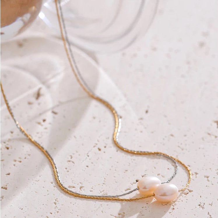 Gold and silver freshwater pearl necklaces styled on light stone