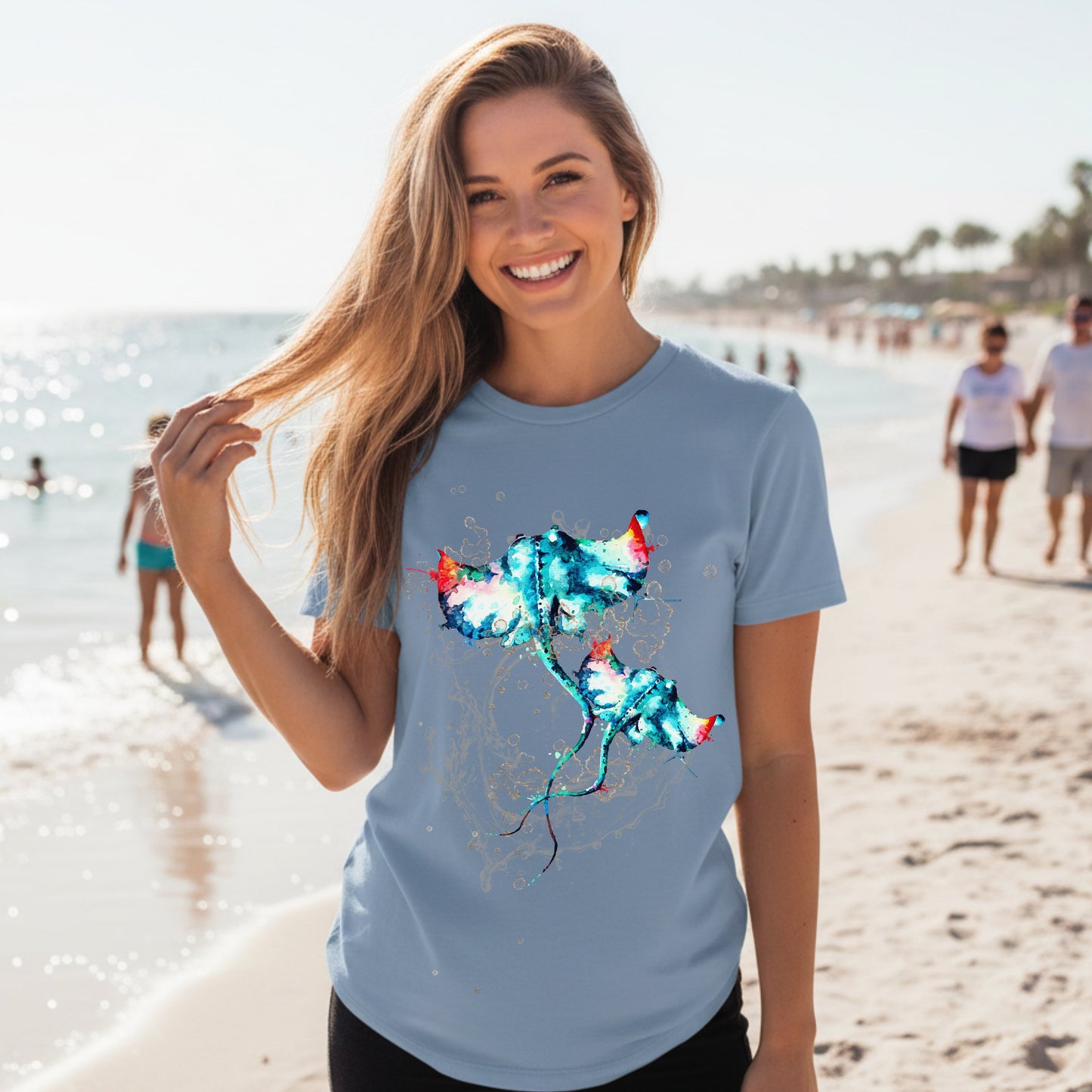 Woman wearing a steel blue color t-shirt with a colorful stingray design on a beach.