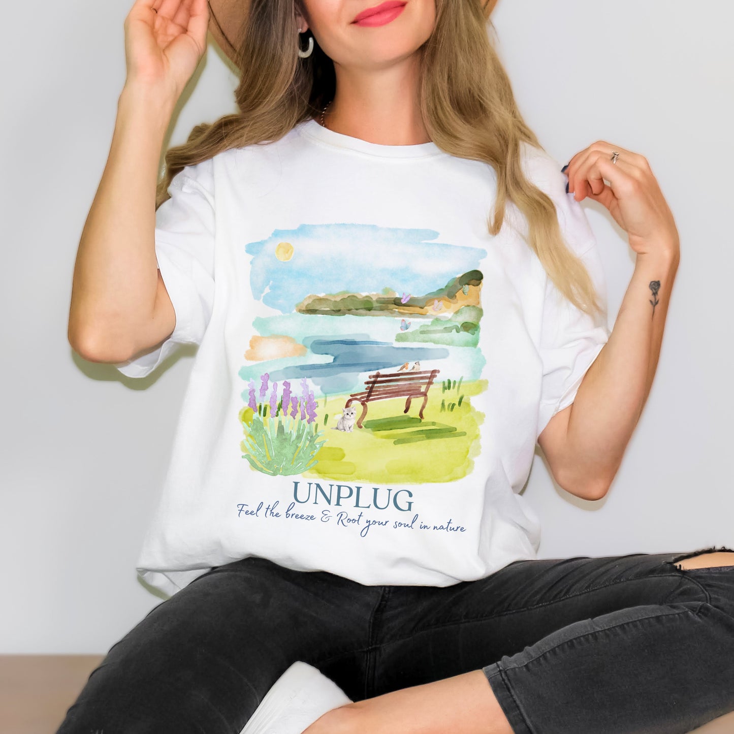 Person wearing a white t-shirt with a nature-themed design and 'UNPLUG' text.
Unplug nature tee in White – Comfort Colors watercolor lake scene shirt by Crossroads Dandelion