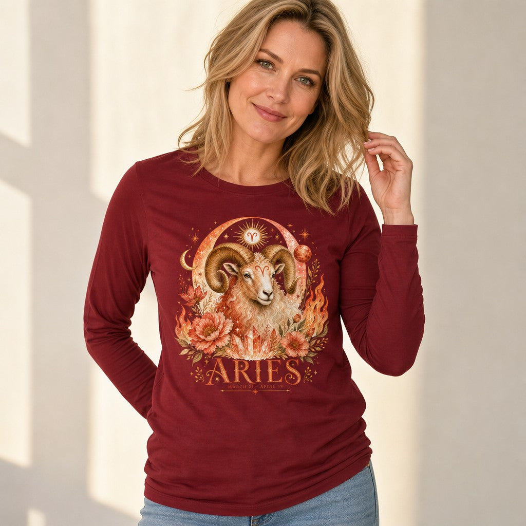 Woman wearing cardinal red Bella Canvas 3501 long sleeve shirt featuring a vintage watercolor Aries ram with swirling horns, surrounded by fiery floral elements, sun, moon, and celestial zodiac motifs, perfect for astrology lovers, indoor natural light, by Crossroads Dandelion