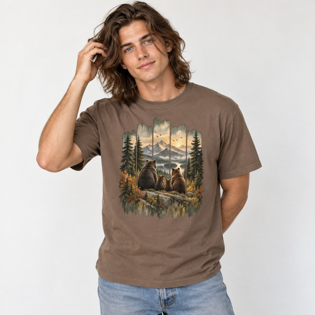Man wearing an espresso Comfort Colors® t-shirt featuring a vintage painted bear family gazing at snow-capped mountains and a golden sunset, rustic cabin wood frame, autumn forest scene, perfect for hikers, campers, and wildlife lovers, by Crossroads Dandelion