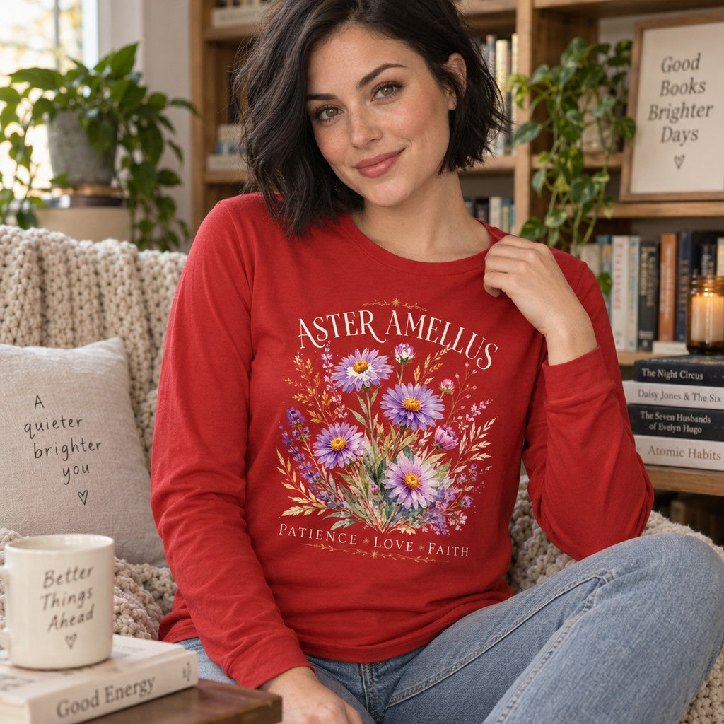 Woman in a red Bella Canvas® 3501 long sleeve featuring a vintage-inspired botanical design with hand-painted aster and amellus flowers and the words 'Patience Love Faith', cozy library scene, romantic floral aesthetic for women and nature lovers, by Crossroads Dandelion