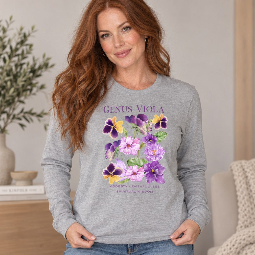 Woman wearing athletic heather Bella Canvas long sleeve featuring a vintage botanical watercolor design of purple, lavender, and yellow viola flowers with green leaves and elegant serif typography, indoors, sophisticated feminine nature and floral enthusiast apparel, by Crossroads Dandelion