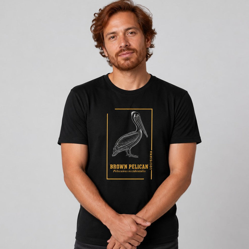 Man wearing black Bella Canvas 3001 t-shirt with vintage engraving style brown pelican illustration framed in golden ochre lines, heritage state birdwatching naturalist gift, classic and contemplative, by Crossroads Dandelion