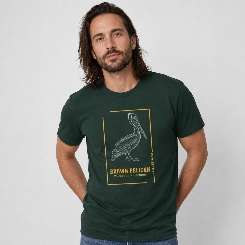 Man wearing forest green Bella Canvas 3001 t-shirt with vintage engraved brown pelican framed in golden ochre line art, heritage-inspired birdwatching shirt for men and naturalists, by Crossroads Dandelion