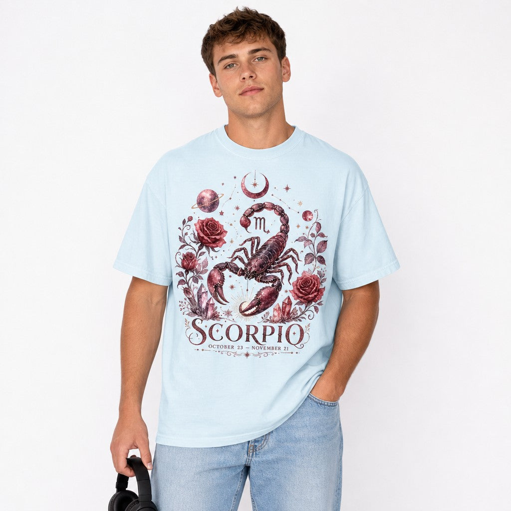 Young man wearing chambray Comfort Colors 1717 t-shirt featuring a vintage hand-drawn scorpio design surrounded by dark red roses, stars, crescent moon, planets, and crystals, astrology lovers celestial style, studio scene, men's graphic tee, by Crossroads Dandelion