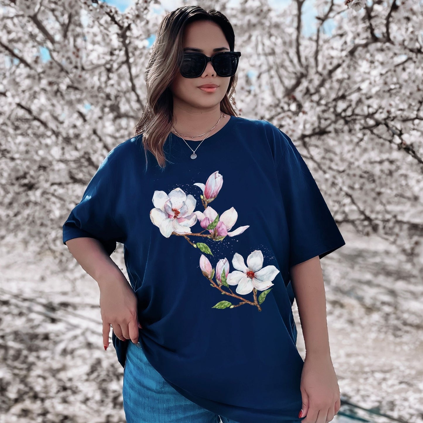 Woman wearing a navy blue vintage magnolia flower tee with watercolor botanical floral design outdoors by Crossroads Dandelion

