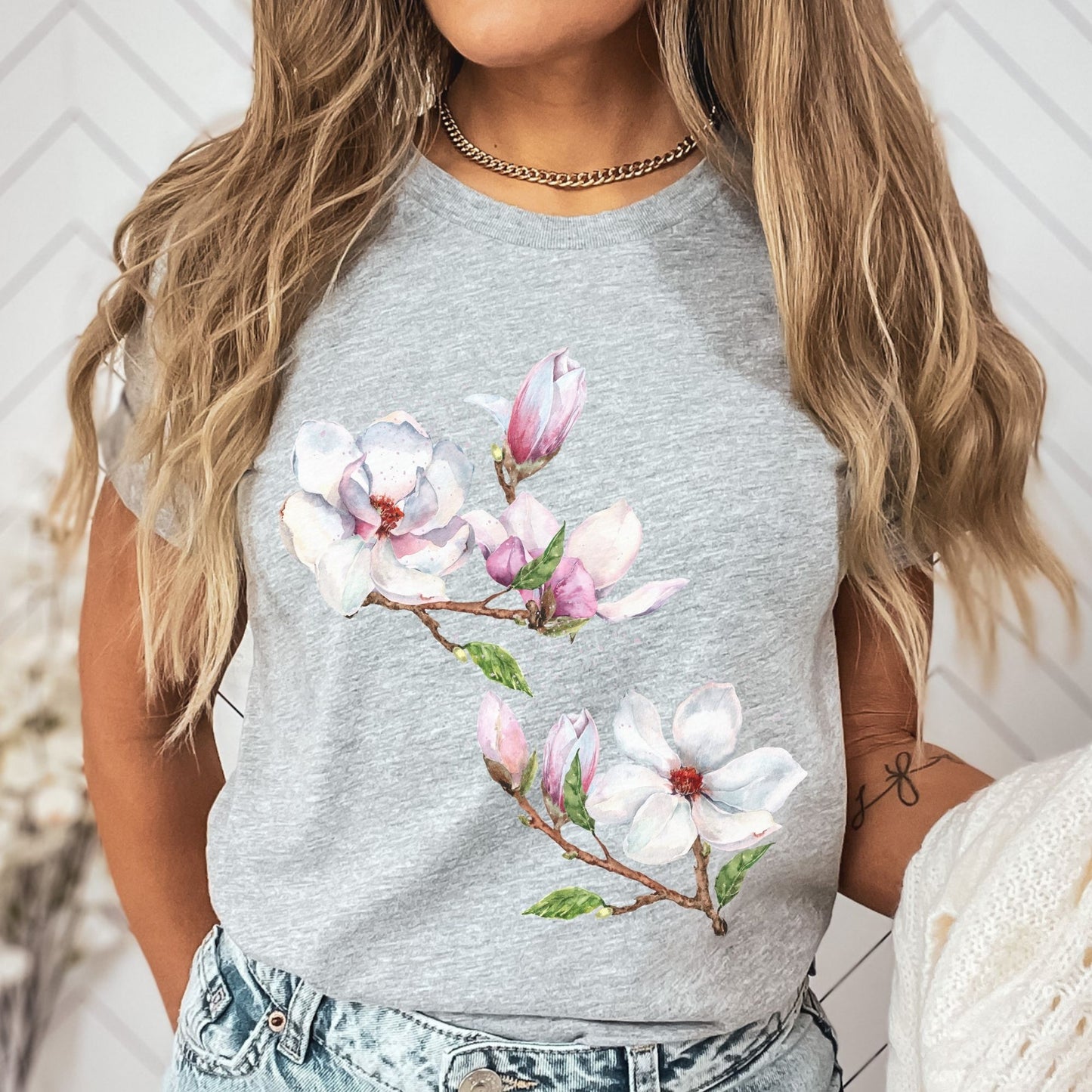 Woman wearing an athletic heather vintage magnolia tee with botanical watercolor floral design by Crossroads Dandelion
