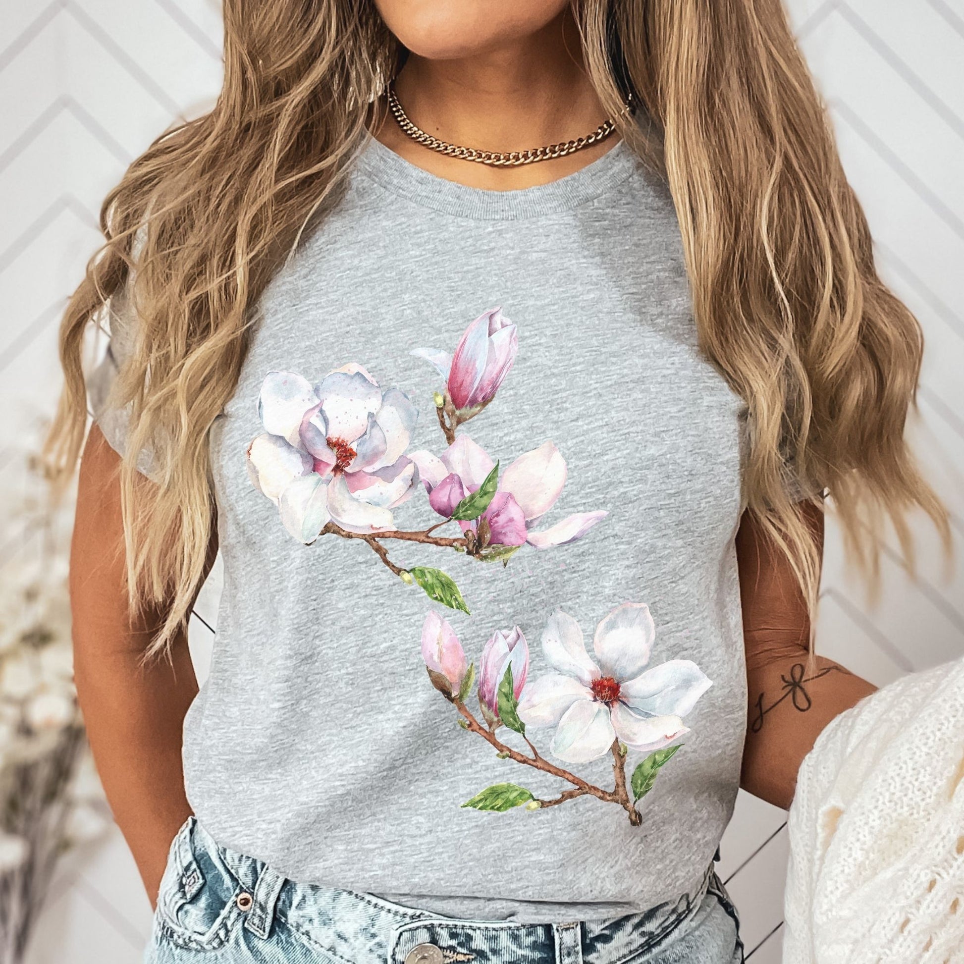 Woman wearing an athletic heather vintage magnolia tee with botanical watercolor floral design by Crossroads Dandelion