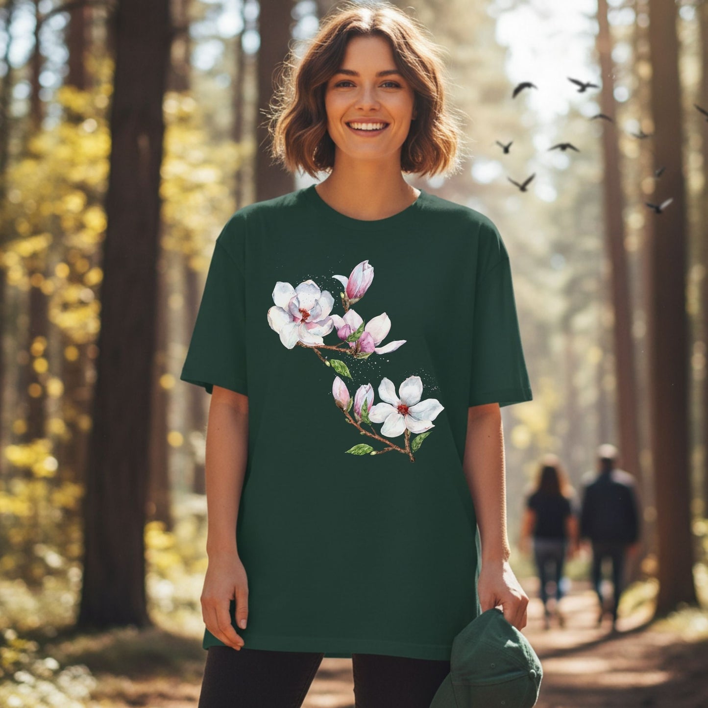 Woman wearing a forest green vintage magnolia tee with watercolor botanical floral design in the woods by Crossroads Dandelion