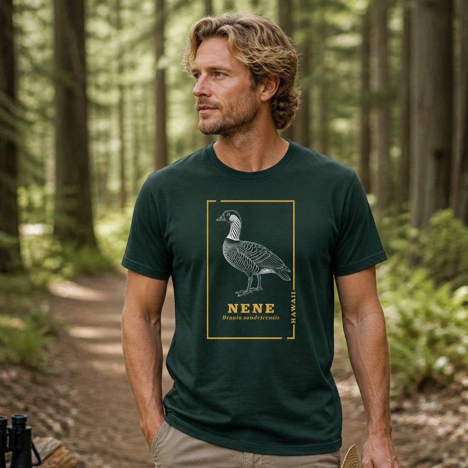 Man in forest green Bella Canvas 3001 t-shirt featuring a vintage line art illustration of a nene goose with golden botanical borders, naturalist style, hiking in a lush woodland scene, perfect for birdwatchers and nature lovers, by Crossroads Dandelion