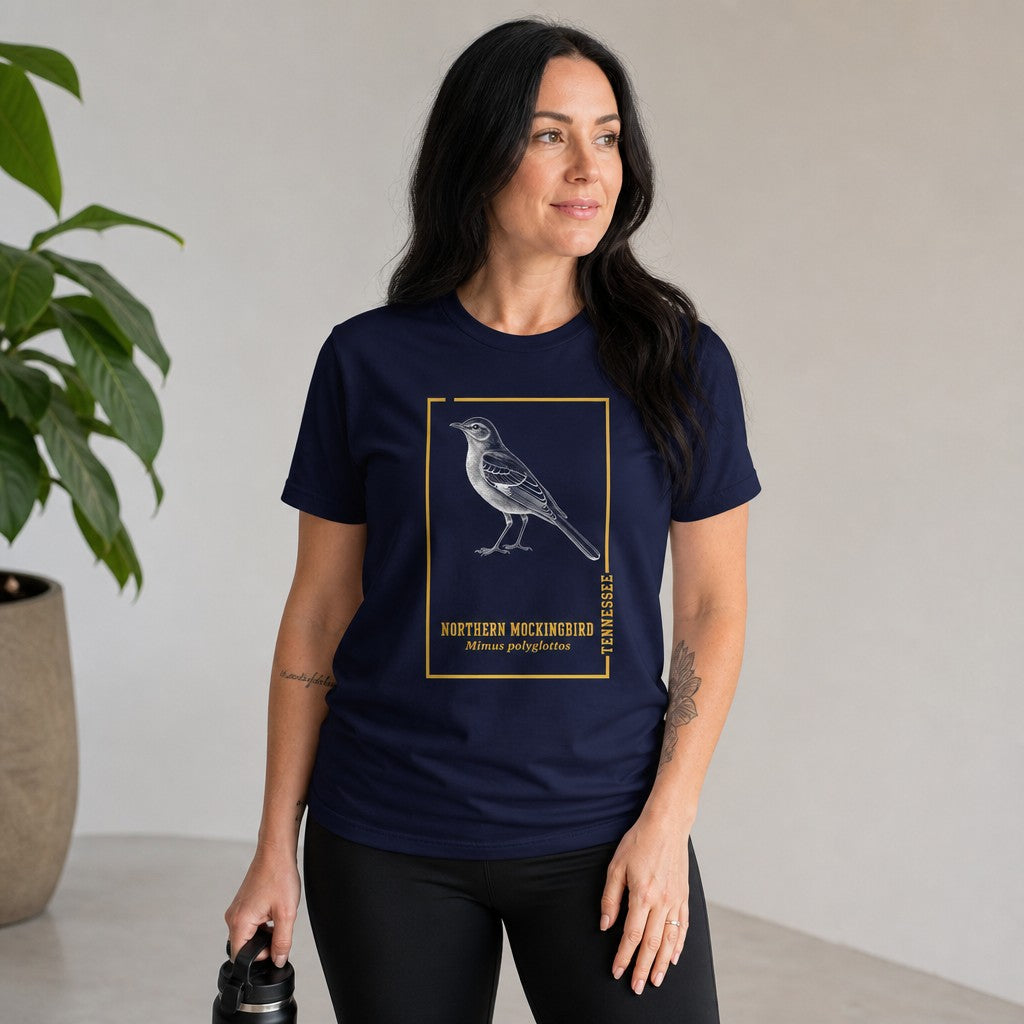 Woman wearing navy Bella Canvas 3001 t-shirt with a vintage northern mockingbird engraving inside a golden botanical frame, ideal for birdwatchers and lovers of Appalachian wildlife illustration, vintage style indoor setting, women's nature lovers tee, by Crossroads Dandelion