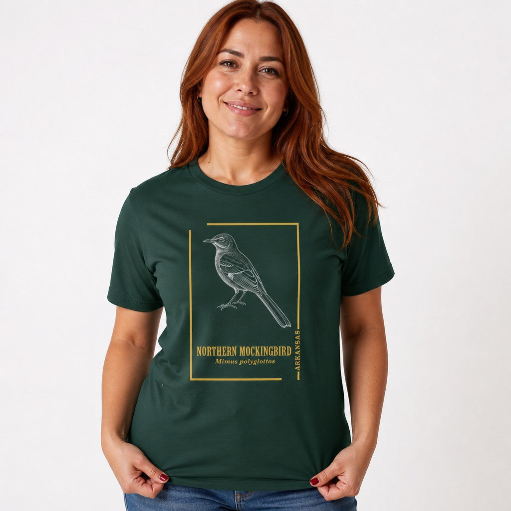 Woman wearing a forest green Bella Canvas 3001 t-shirt featuring a hand-rendered vintage illustration of a Northern Mockingbird with a gold border, vintage field guide style design for birdwatchers and nature lovers, by Crossroads Dandelion