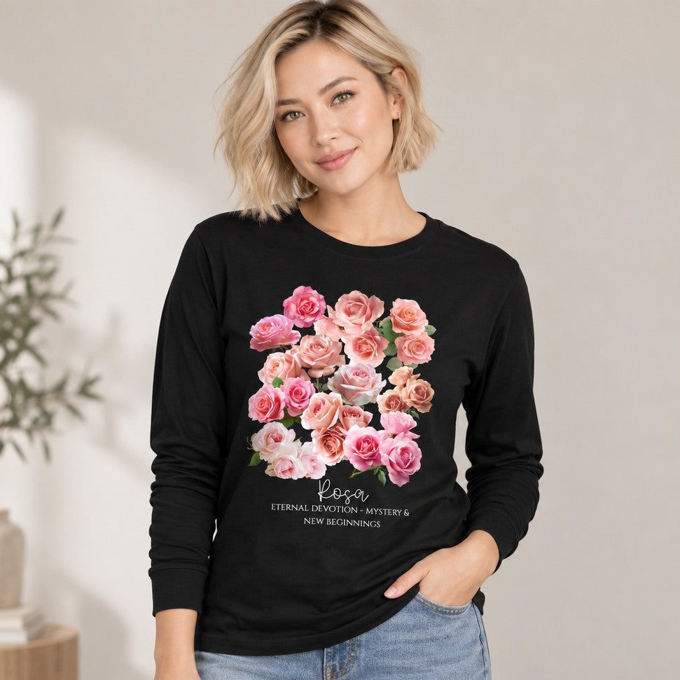 Woman in a black Bella Canvas 3501 long sleeve shirt featuring a vintage-inspired watercolor bouquet of pink and blush roses, romantic botanical floral design for garden and nature lovers, photographed in a cozy indoor setting, by Crossroads Dandelion