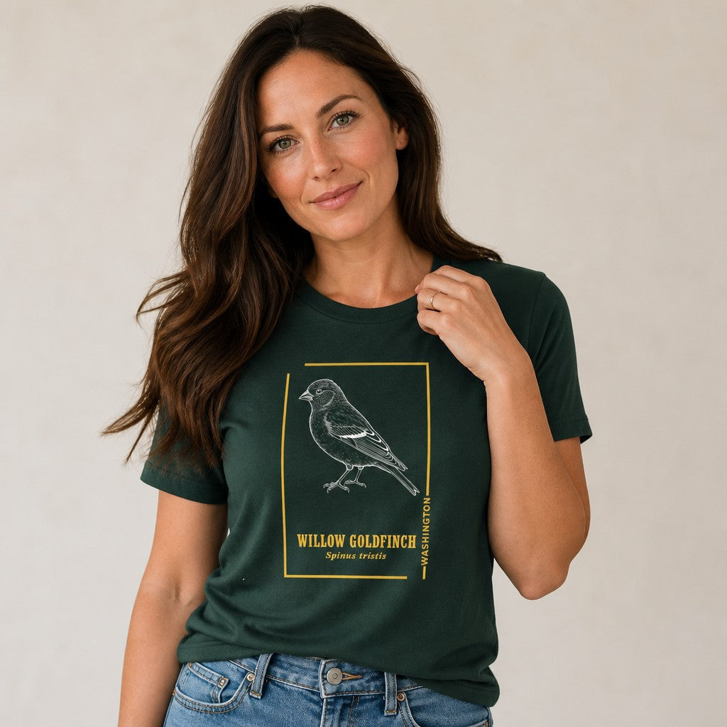 Woman in a forest green Bella Canvas 3001 t-shirt featuring a vintage etched willow goldfinch framed with golden accents and classic serif text, inspired by botanical field journal sketches, designed for nature enthusiasts and birdwatchers, by Crossroads Dandelion