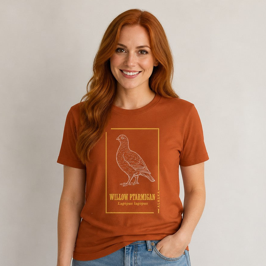 Woman wearing an autumn-colored Bella Canvas 3001 t-shirt with a vintage hand-drawn willow ptarmigan, Alaska state bird, framed by golden botanical line art, evoking naturalist field journal nostalgia, perfect for birdwatchers, wildlife fans, and cottagecore style, by Crossroads Dandelion