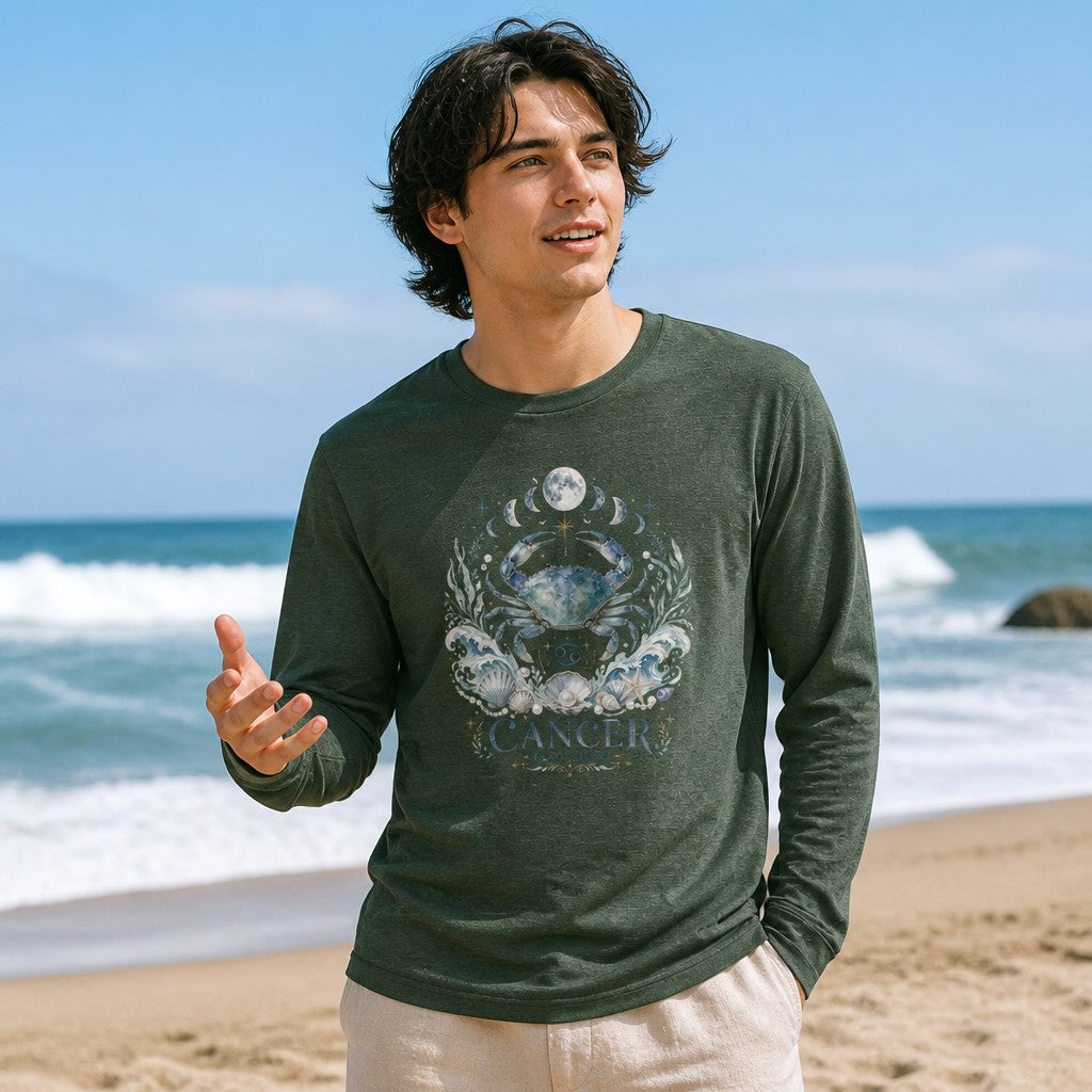 Man in heather forest Bella Canvas 3501 long sleeve featuring a watercolor celestial crab with ocean waves, seashells, pearls, moon phases, and Cancer zodiac design, on a beach, dreamy cosmic astrology shirt for men and nature lovers, by Crossroads Dandelion
