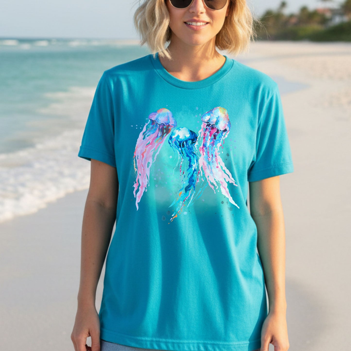 Woman wearing a turquoise t-shirt with jellyfish design on a beach