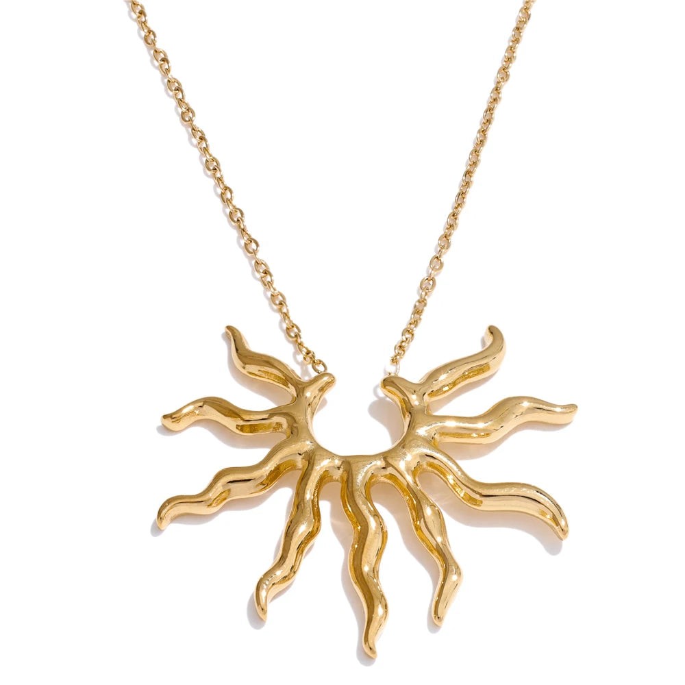 Gold wavy sun pendant necklace on a fine cable chain, front view on white