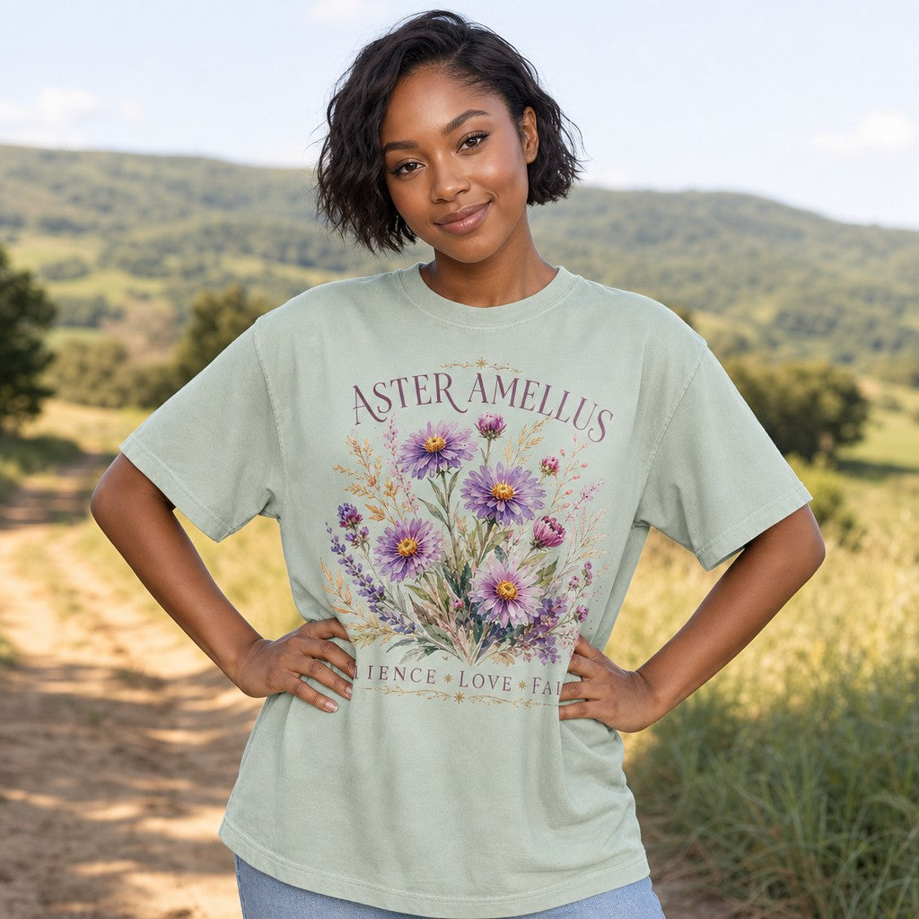 Woman wearing a bay green Comfort Colors t-shirt with a hand-painted watercolor Aster Amellus floral bouquet and wild botanicals, whimsical botanical design, perfect for garden and nature lovers, photographed on a scenic country path, by Crossroads Dandelion