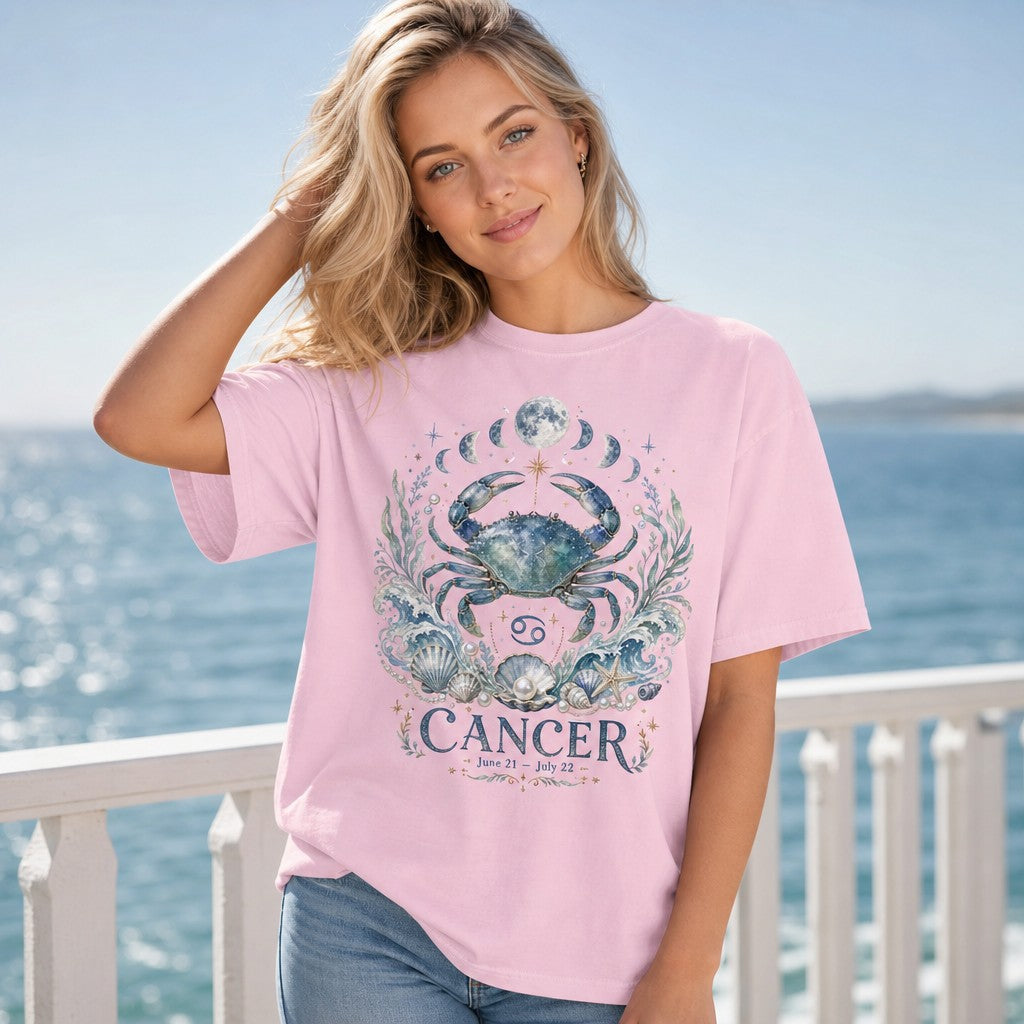 Woman wearing a blossom pink Comfort Colors t-shirt adorned with whimsical, hand-painted Cancer zodiac art featuring a celestial crab, lunar phases, ocean waves, seashells, and pearls, in an enchanting seaside setting, perfect for astrology and water sign lovers, by Crossroads Dandelion
