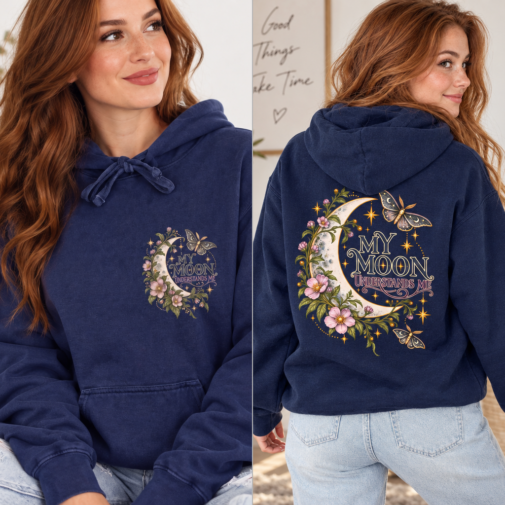 A woman modeling a navy blue hoodie in a split front-and-back view. The front shows a small floral moon graphic on the left chest, and the back shows a large matching graphic with a crescent moon, butterflies, flowers, stars, and the words “MY MOON UNDERSTANDS ME".