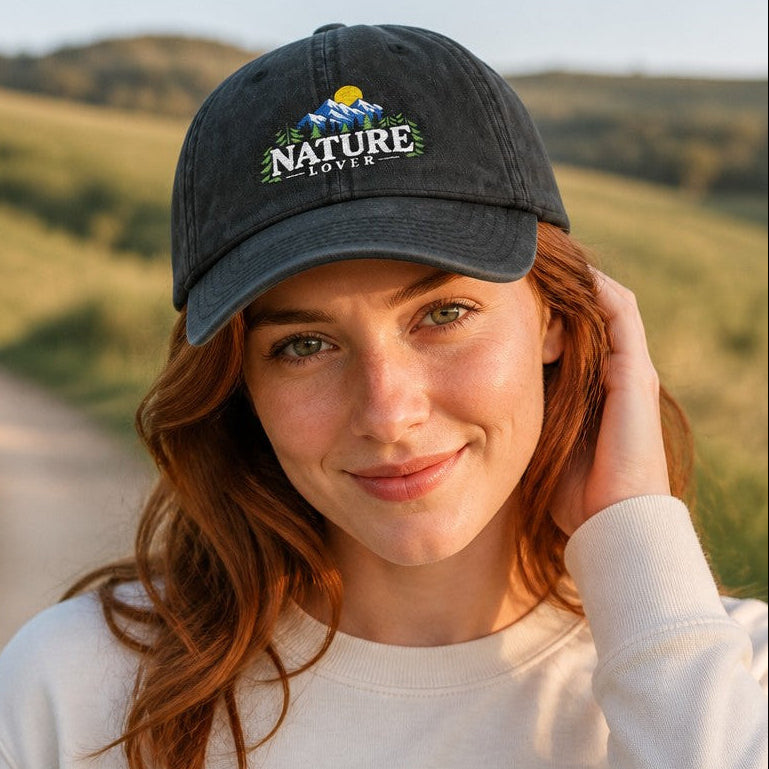 Woman wearing a black baseball cap with whimsical embroidered nature lover design featuring flowers and mountains, holding a mug on a scenic outdoor path, perfect for outdoor enthusiasts and women who love nature, by Crossroads Dandelion