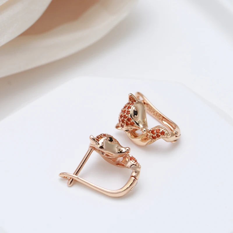 Rose gold fox earrings with one hinged lever-back hoop open to show the closure